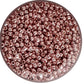 Close-up of rose gold metallic beads in a round container