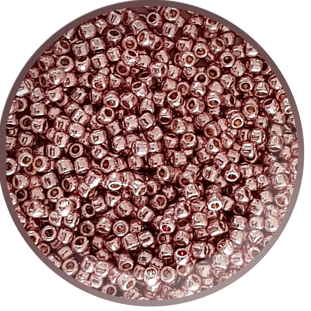 Close-up of rose gold metallic beads in a round container