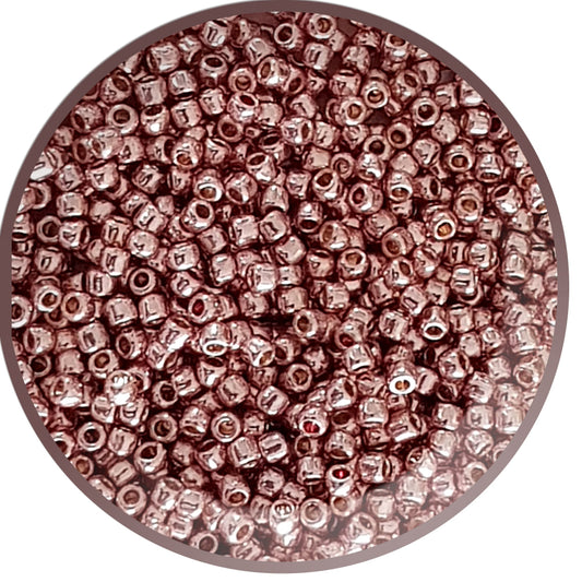 Close-up of rose gold metallic beads in a round container