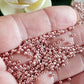 close up of sweet blush galvanized on a hand.
