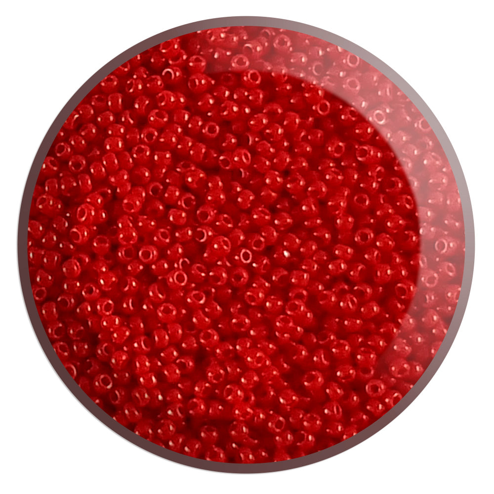 A close-up view of cherry red opaque round Toho seed beads.