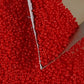 Close up red beads with a  triangle scoop.