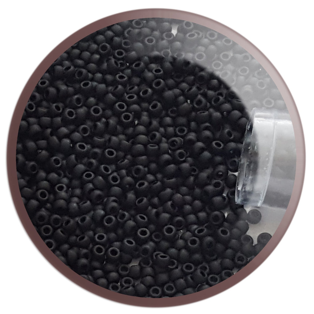 A clear plastic container filled with round jet black frosted opaque Toho seed beads, 15/0, 