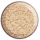 A close-up view of light beige opaque luster round Toho seed beads.