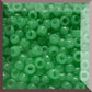 A collection of jade green, round Toho seed beads arranged in a pattern.