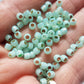 close up milky peridot beads on a hand.