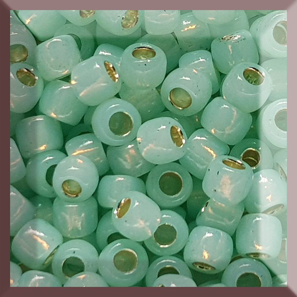 A collection of milky peridot silver lined round Toho seed beads