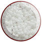 A bowl filled with white frosted opaque pastel round Toho seed beads.