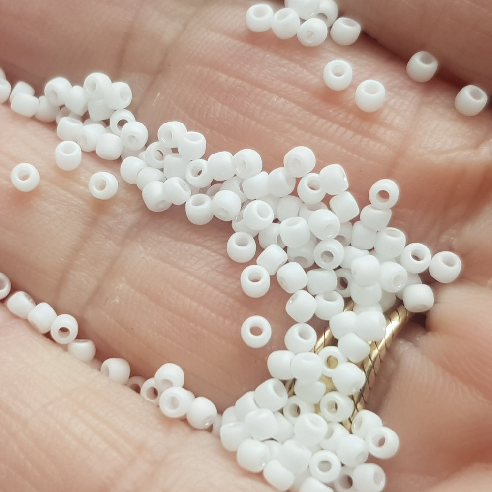 close up of white frosted beads on a hand.