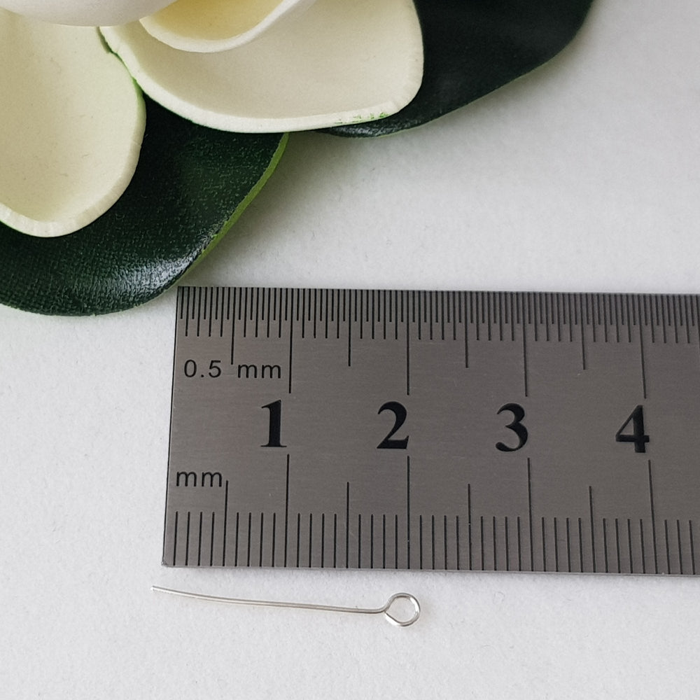 Eye Pins 20mm on a ruler white background flower top corner.