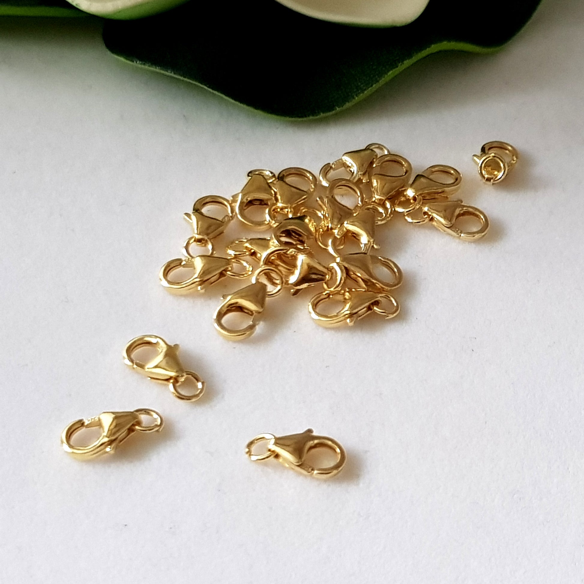 a bunch of gold filled lobster claw clasps on white background