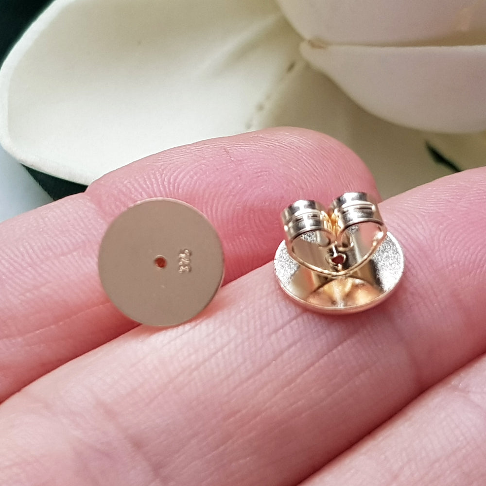 Ear backs in 9ct yellow gold - Earring Findings between fingers