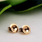 A pair of 9ct yellow gold butterfly ear backs for earrings, displayed against a green leafy background.