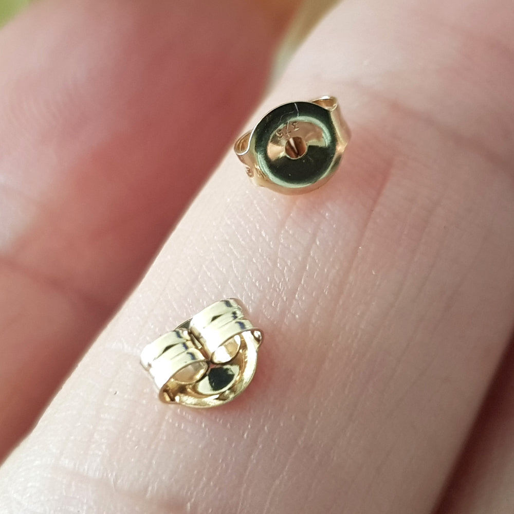 Earring Backs Gold on a finger