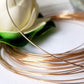 Close view of 9ct yellow gold wire blurred background with a white flower.