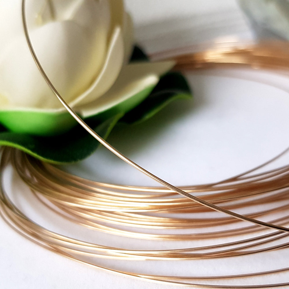 Close view of 9ct yellow gold wire blurred background with a white flower.