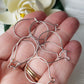 A bunch on medium kidney hooks on a hand blurred flower background