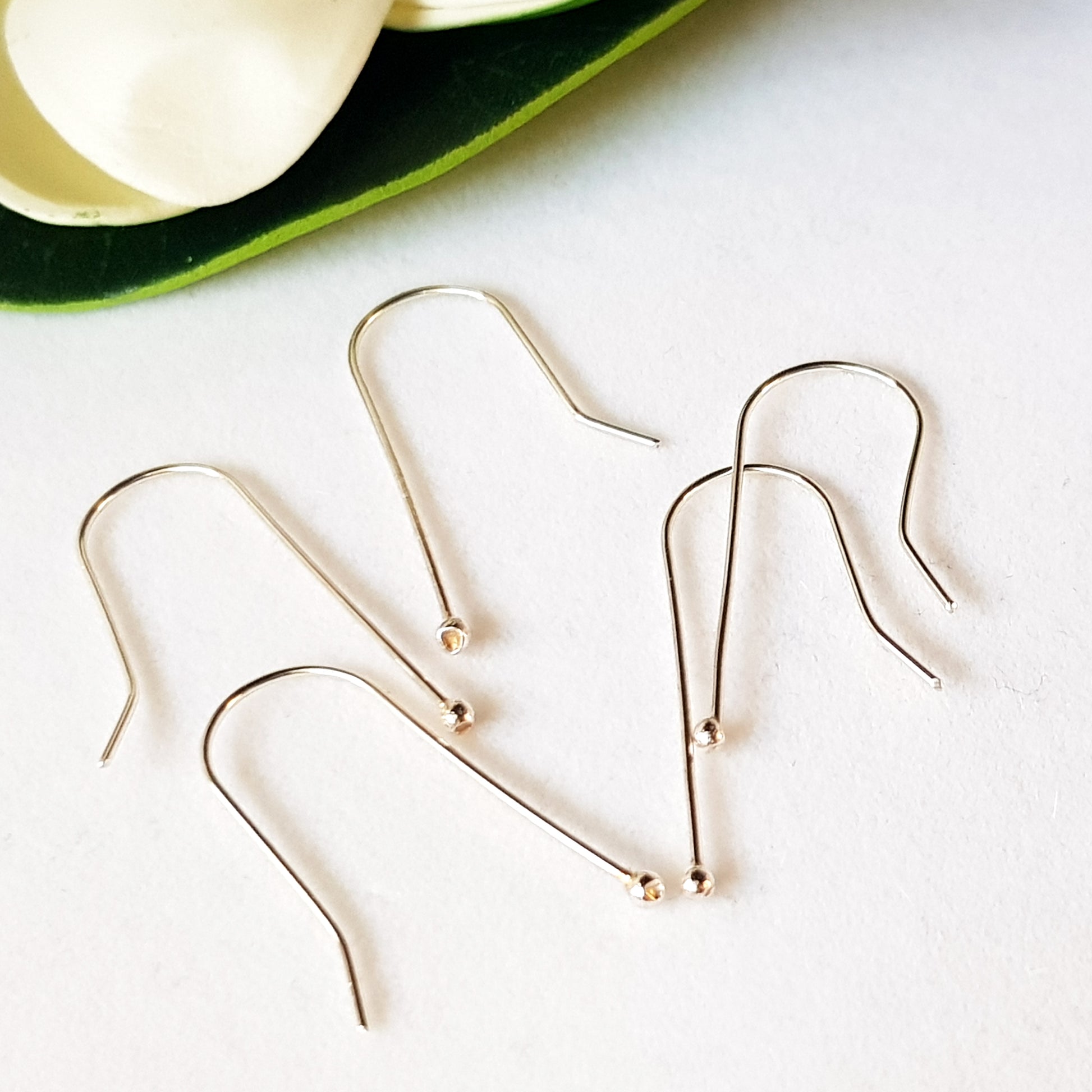A bunch of handmade balled straight earring hooks on  a white background