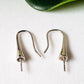 A pair of sterling hooks on a white background.