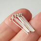 Eye Pins 20mm between fingers on a white background.
