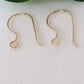 gold earring hooks handmade laying on a white background