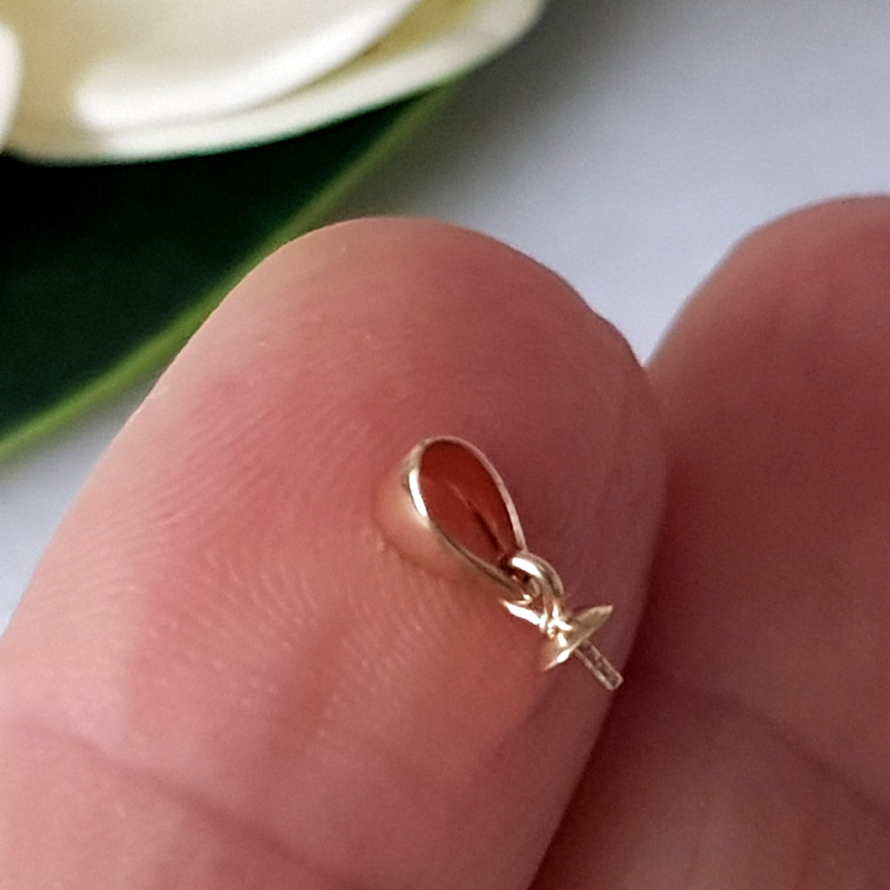 9ct yellow gold pendant drop on a finger close up,