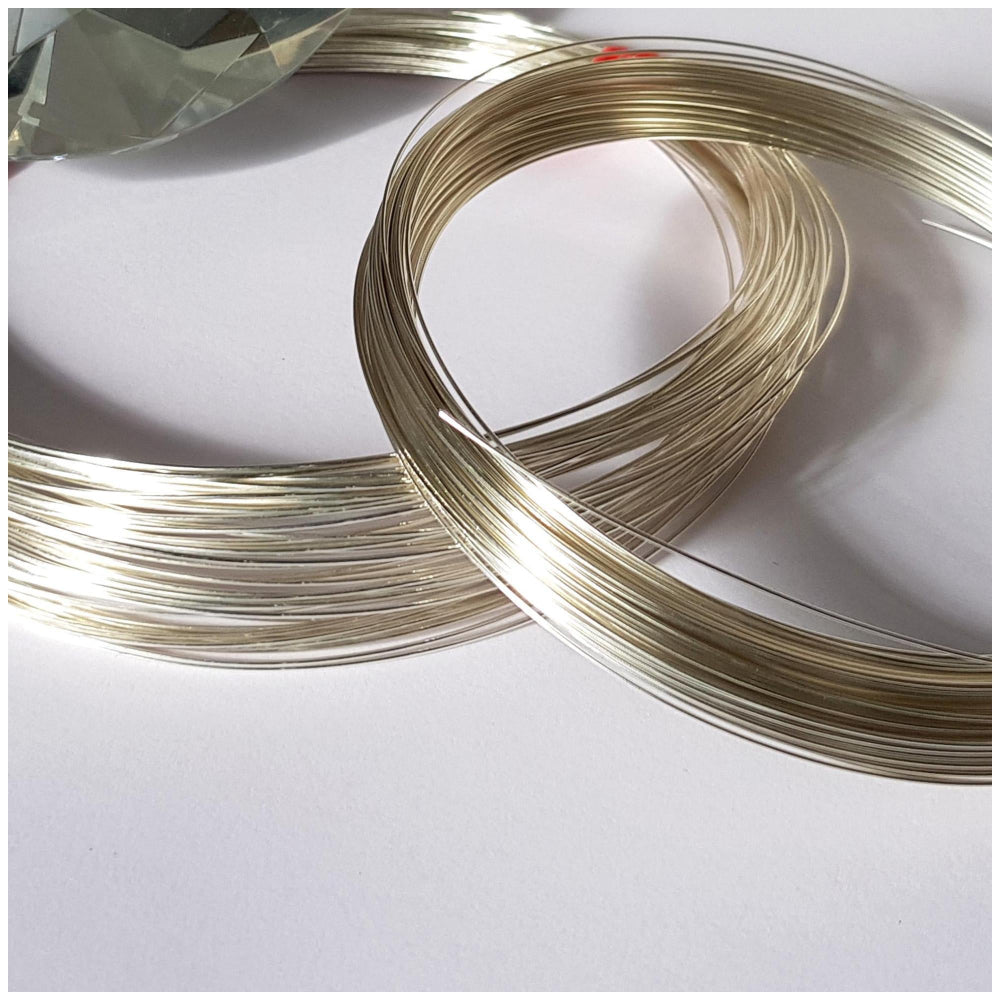 A coiled piece of sterling silver wire on a light background, intended for jewelry making.