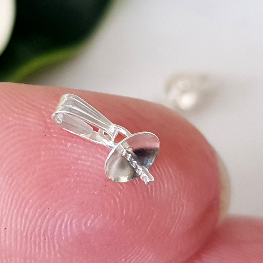 Sterling silver 925 Pendant Drop on a finger blurred background.