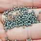 11/0 Toho Seed beads in blue slate galvanized TR-PF565 close up on a hand.