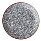 A bowl filled with black diamond transparent luster round Toho seed beads. circle white background.
