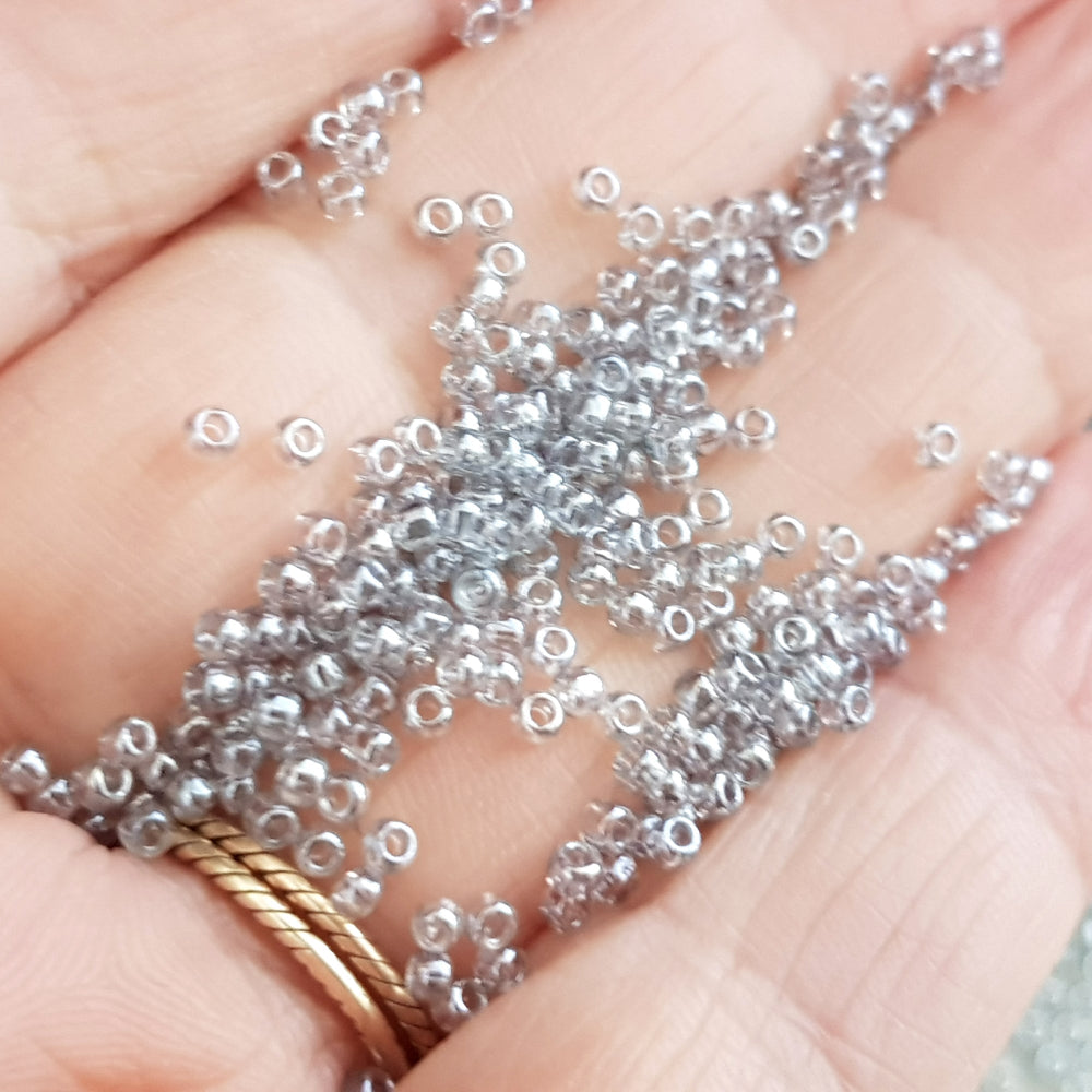 Close up 11/0 Toho Black Diamond luster beads on a hand.
