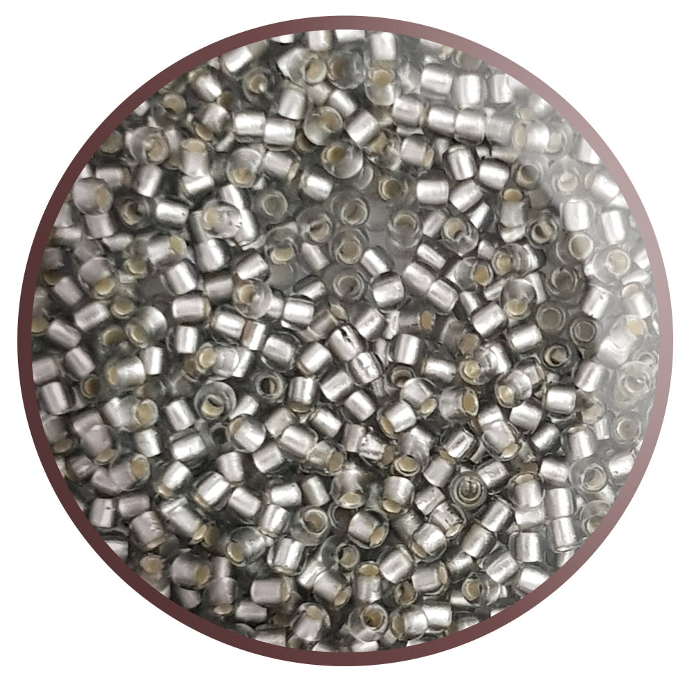 A collection of black diamond silver lined matte Toho round seed beads. 11/0 in a circle with white background,