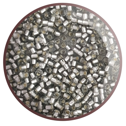 A collection of black diamond silver lined matte Toho round seed beads. 11/0 in a circle with white background,