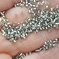 A collection of black diamond silver lined matte Toho round seed beads. 11/0 on a hand