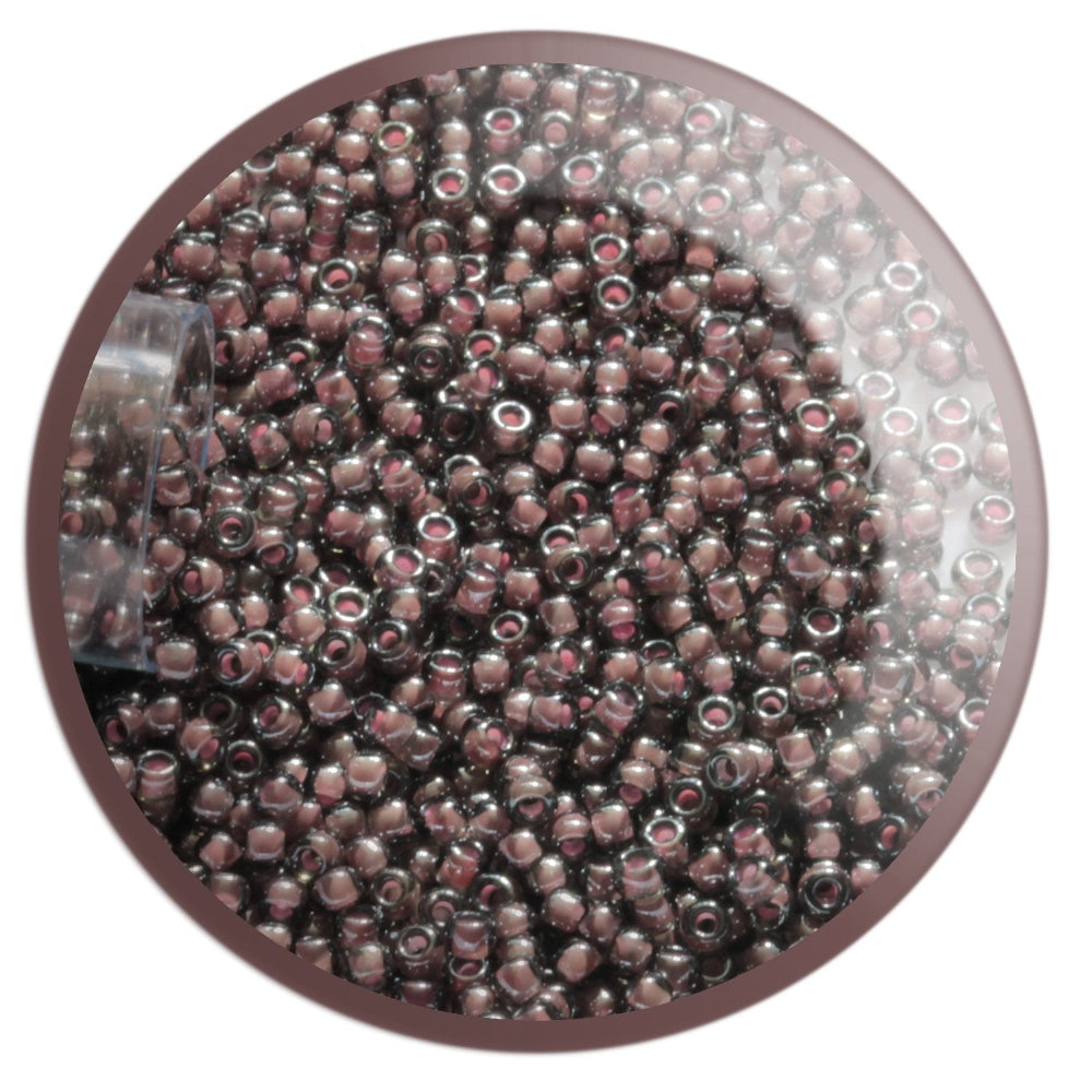 11/0 TR-367 Black Diamond Pink Lined Lustre Round Toho Seed Beads in a circle with white background.