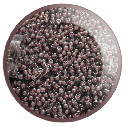 11/0 TR-367 Black Diamond Pink Lined Lustre Round Toho Seed Beads in a circle with white background.