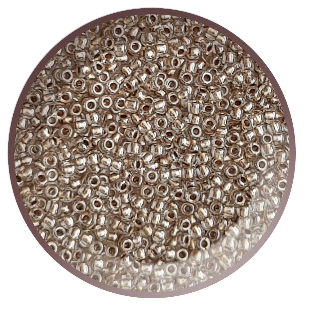 A plate full of round Toho seed beads in Crystal Gold Lined color. 11/0 TR-989