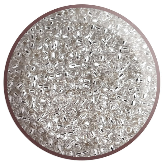 Toho 11/0 Crystal Silver-Lined TR-21 in a circle white background,