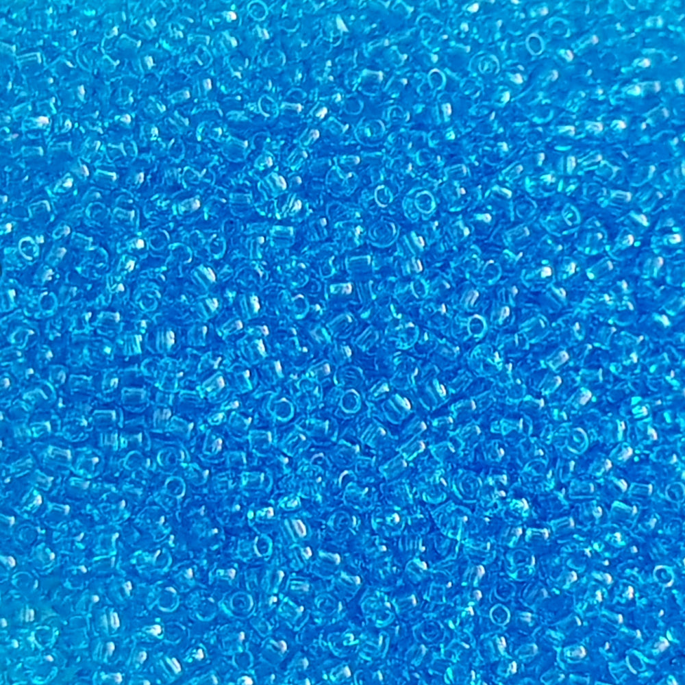 11/0 Toho seed beads in dark aquamarine transparent close up.