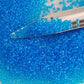 11/0 Toho seed beads in dark aquamarine transparent with a beading scoop.