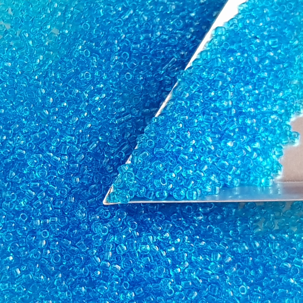 11/0 Toho seed beads in dark aquamarine transparent with a triangle scoop.