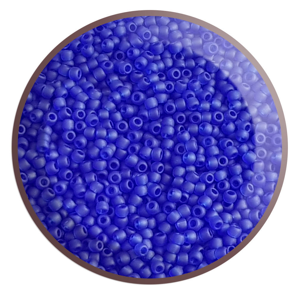 A close-up view of dark sapphire frosted transparent round Toho seed beads.