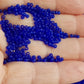 11/0 Toho Seed Beads in Dk. Sapphire frosted transparent on a hand.