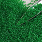 11/0 Toho seed beads in grass green frosted transparent TR-7BF with a beading scoop.