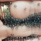 11/0 Toho Seed beads in grey transparent TR-9B close up on a hand.
