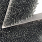 11/0 Toho Seed Beads in grey transparent with a triangle scoop.