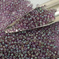 A close-up view of Hydrangea Gold Luster Round Toho Seed Beads 11/0 showing their lustrous finish and multicolored appearance. with a beading scoop.