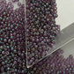 A close-up view of Hydrangea Gold Luster Round Toho Seed Beads 11/0 showing their lustrous finish and multicolored appearance. triangle scoop.
