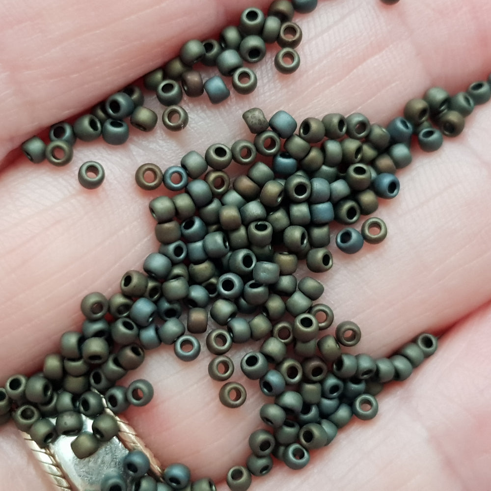 11/0 Toho Seed Beads in Iris Brown Metallic Frosted TR-83F on a hand.