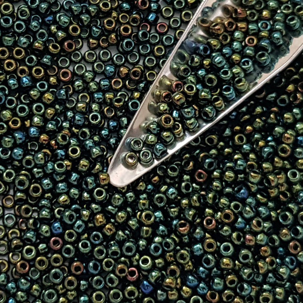 11/0 Toho Seed Beads in Iris Green/Brown Metallic TR-84 with a beading scoop.